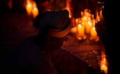 Candlelit dining setup at Amanoi with flickering flames illuminating the table in darkness.