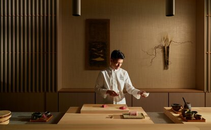 Chef Takuma prepara omakase al bancone in legno presso Nama, il ristorante di Aman New York.