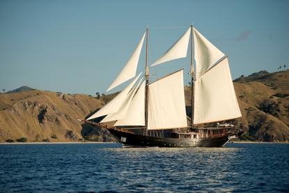Classic sailing vessel Amandira under full sail off Indonesia's coast.