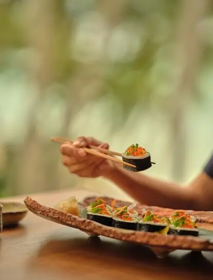Nama sushi platter at Amanpuri's dining venue in Thailand, featuring artfully arranged nigiri on wooden boards.