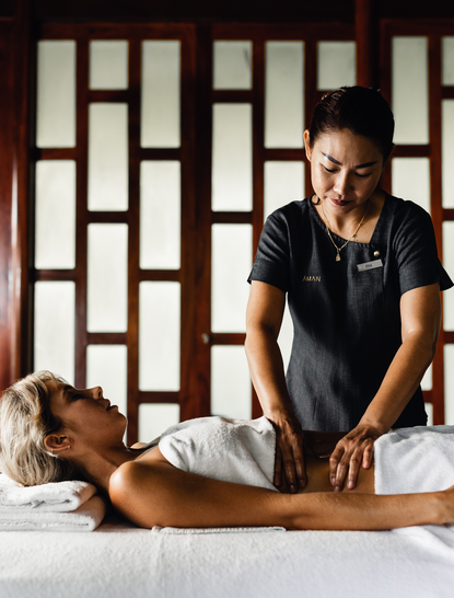 Therapist performing a wellness stomach massage at Amanpuri Thailand spa.