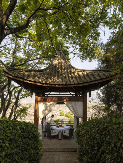 大研安缦度假村的传统亭阁，绿树成荫，入口处可见车道。