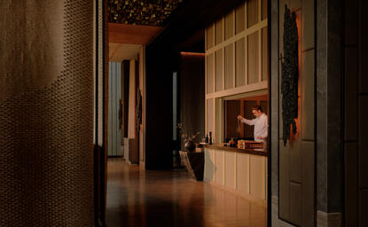 Corridor at Aman Nai Lert Bangkok with warm wooden panelling and soft lighting.