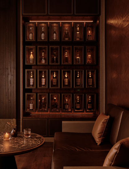 حانة السيجار في أمان ناي ليرت بانكوك، تعرض رفوفاً مضاءة بزجاجات المشروبات الروحية.