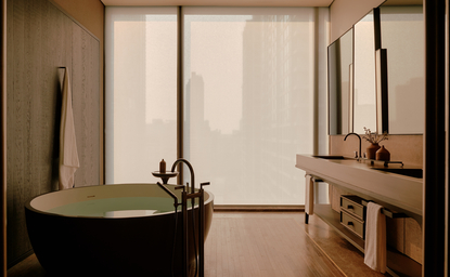 アマン ナイラート バンコクのホテル、ルーム167のバスルーム。緑色の円形浴槽と木製の洗面台がある。