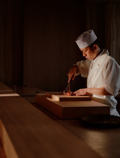 Artisan craftsperson at work in a wooden boat at Aman Nai Lert Bangkok.