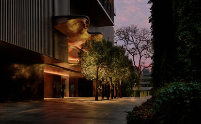 Amanjiwo hotel exterior illuminated at dusk, with warm lighting highlighting the building's architecture and surrounding trees.