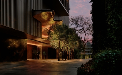 Aman Nai Lert Bangkok hotel exterior at dusk, illuminated entrance with manicured gardens and trees.