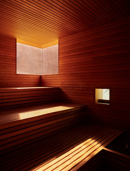 Sauna spa avec boiseries rouges chaudes et lumière apaisante à Amangiri.