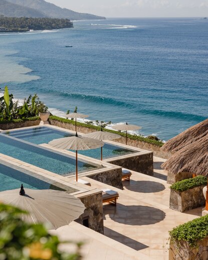 安缦丘澜度假村的主游泳池，俯瞰巴厘岛海岸线和蔚蓝海水。