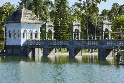 アマンキラ リゾートのウジュン宮殿を望む、水辺に建つ青い建造物と橋。