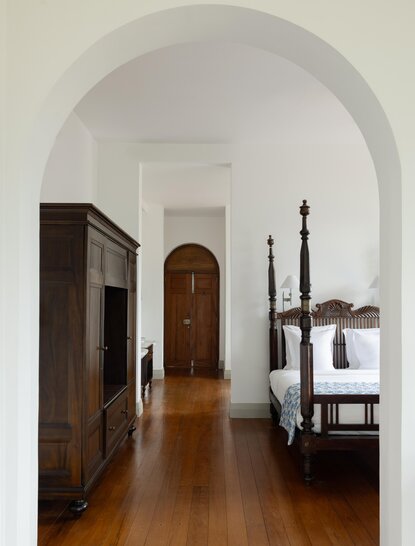 Amangalla suite with arched corridor leading to wooden furnishings and period details.