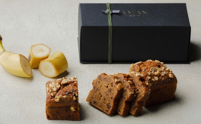 アマン京都のリゾートで提供されるバナナパウンドケーキ、スライスされた状態で黒いボックスとともに表示。