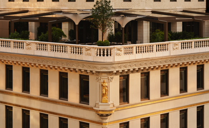 Exterior view of the Crown Building at Aman New York, featuring neoclassical architecture with ornate balconies and arched windows.