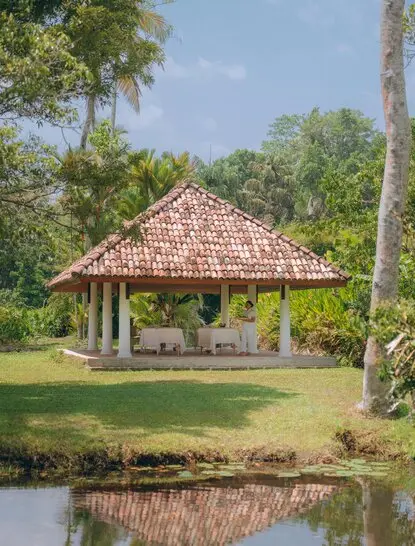 Spa pavilion at Amangalla set beside a pond, surrounded by tropical gardens and tall palms.
