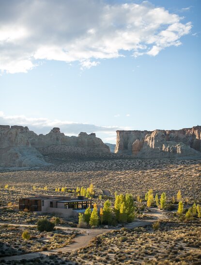 Mesa-top home at Amangiri with desert landscape and rock formations under blue sky.