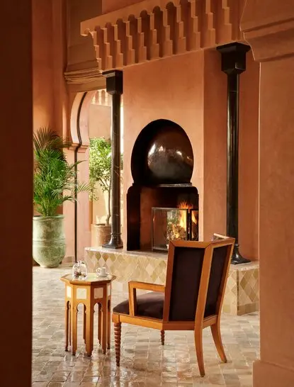 Foyer avec cheminée traditionnelle marocaine à Amanjena, resort au Maroc.