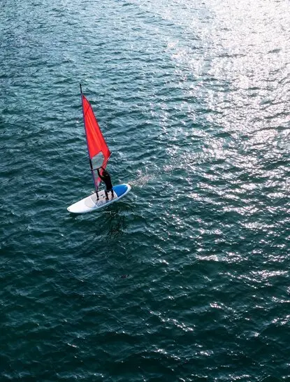 Kite surfer with red sail on turquoise waters at Amanoi, Vietnam.