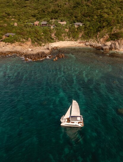 Catamaran sailing off the Vietnamese coast near Amanoi, aerial view.