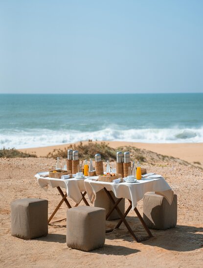 Safari breakfast spread on beach at Amanwella, Sri Lanka, with ocean view.