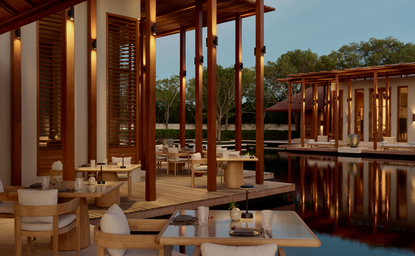 Restaurante principal de Amanyara resort con columnas de madera y vistas al agua.