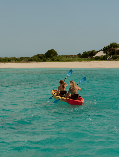 アマンヤラ リゾートでのカヤック体験。ターコイズブルーの海で赤いカヤックに乗る人々。