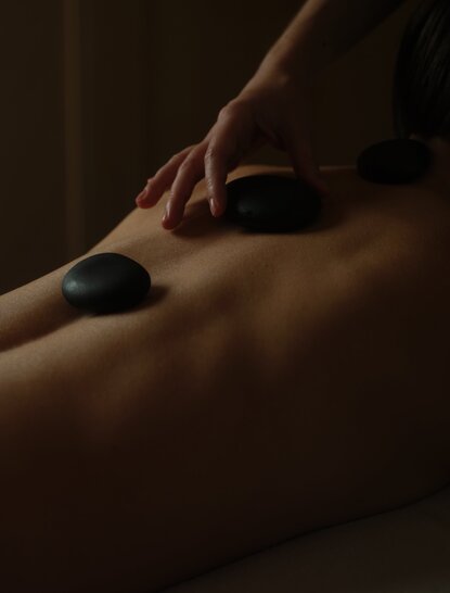Therapist's hands performing a spa wellness massage at Aman Le Mélézin resort, France.