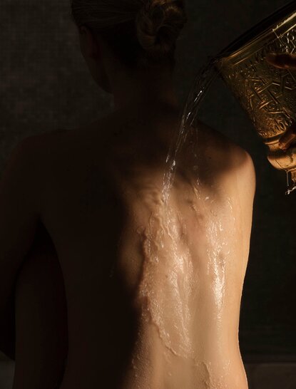 Agua tibia corre por la espalda de un huésped durante un tratamiento en el spa del Aman New York.