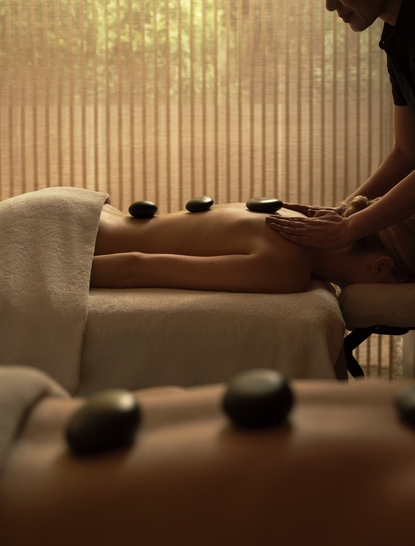 Couples massage treatment room at Aman New York with warm lighting, comfortable seating, and calming spa atmosphere.