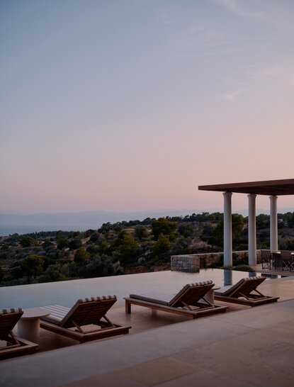 アマンゾイのリゾートにある3ベッドルームヴィラのテラスから、夕暮れ時のエーゲ海を望む。