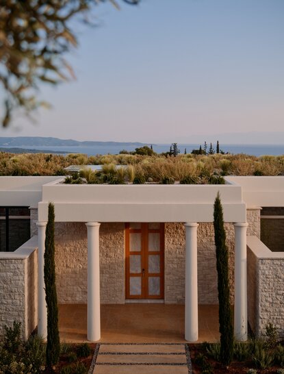 アマンゾイ リゾートの3ベッドルームヴィラの玄関、夕暮れ時にエーゲ海を見渡す。