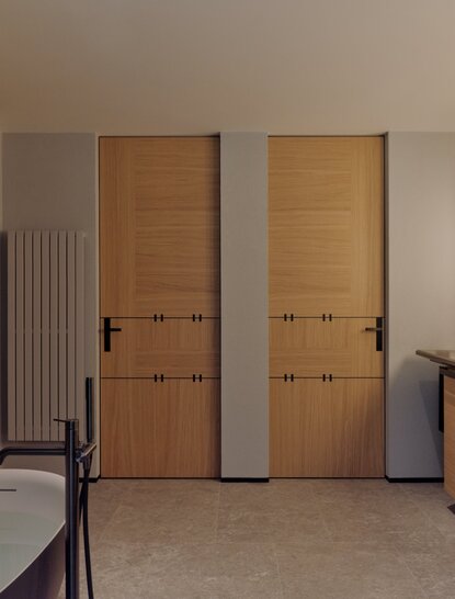 Junior Suite bedroom with twin wooden doors and radiator at Aman Rosa Alpina.