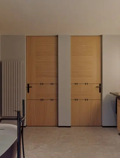 Junior Suite bedroom with dual wooden doors and minimalist Alpine interiors at Aman Rosa Alpina.