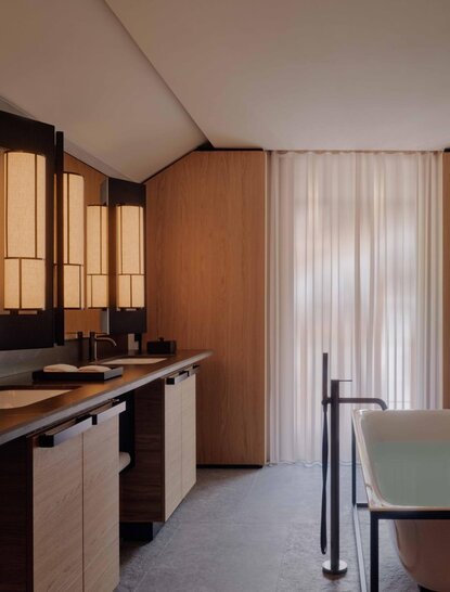 Bathroom with wooden cabinetry and vertical blinds at Aman Rosa Alpina resort.