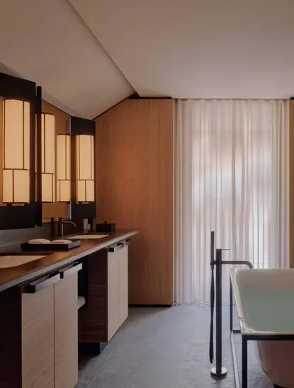 Bathroom with wooden cabinetry and vertical blinds at Aman Rosa Alpina resort.