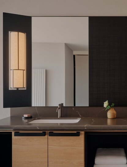 Premier Suite bathroom at Aman Rosa Alpina with wooden vanity, large mirror, and minimalist design.