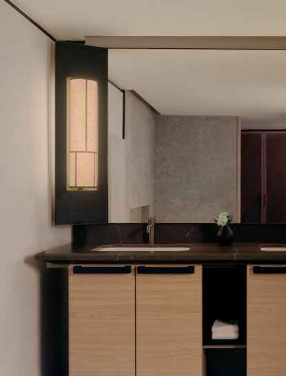 Superior Room bathroom with black vanity and warm lighting at Aman Rosa Alpina resort.