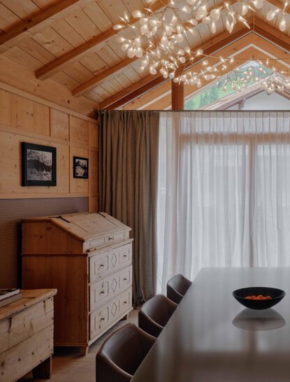 Zeno Suite at Aman Rosa Alpina resort, with wooden beams, pendant lighting and alpine views.