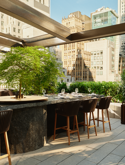 Terrasse bar ombragée avec vue sur les toits de Manhattan, à Aman New York.