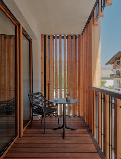 Camera da letto principale con balcone in legno, Aman Rosa Alpina, resort italiano.