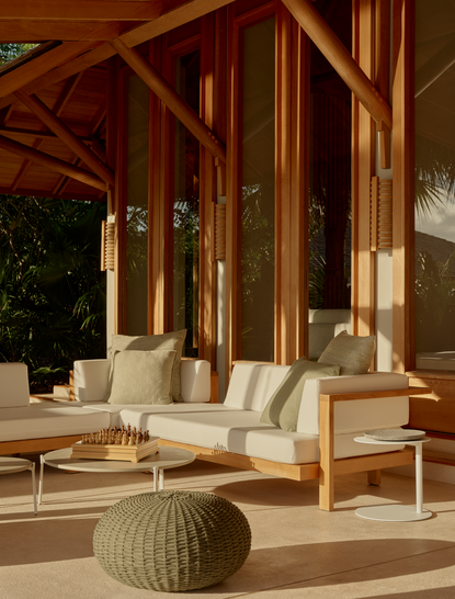 Villa outdoor living area at Amanyara resort, Turks and Caicos, with wooden furniture and terracotta flooring.