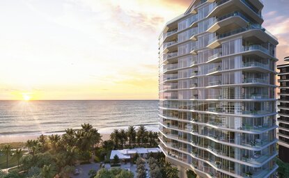 Aman Residences Miami Beach exterior at sunset, with oceanfront views and curved balconies.
