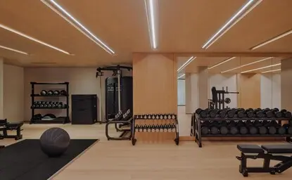 Modern gym at Aman Rosa Alpina with wooden ceiling, exercise equipment, and wellness facilities.