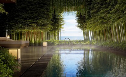 Architectural render of Aman Singapore's spa house pool at dusk, with illuminated pavilion reflected in still water.