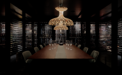 Dining room at Aman Rosa Alpina resort with ornate chandelier and dark wood panelling.
