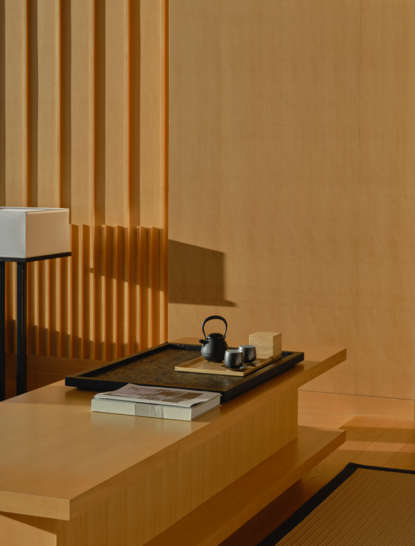 Détail d'une Grand Suite à Aman Tokyo, montrant un bureau en bois clair avec accessoires minimalistes et panneaux en bois vertical en arrière-plan.