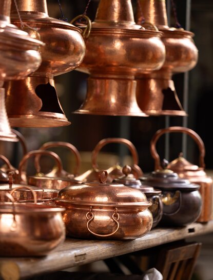 大研安缦度假村展示的铜制烹饪器具和传统蒸馏设备。