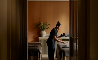 Wellness spa attendant prepares treatment space at Aman New York's banya wellness facility.