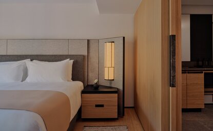 Principal Suite bedroom at Aman Rosa Alpina resort, featuring twin beds and warm wooden furnishings.
