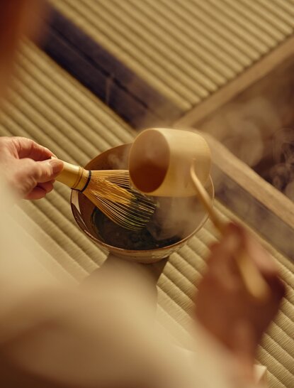 安缦京都茶舍内，手持茶碗进行传统茶道仪式。